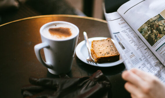 Kaffeetasse auf Tisch mit Zeitung