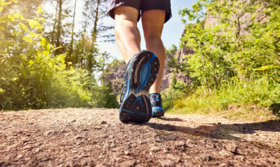 Mann joggt oder wacht im Freien auf einem Fußweg oder Pfad Konzept für gesunden Lebensstil, Sport ausüben, laufen und Fitness
