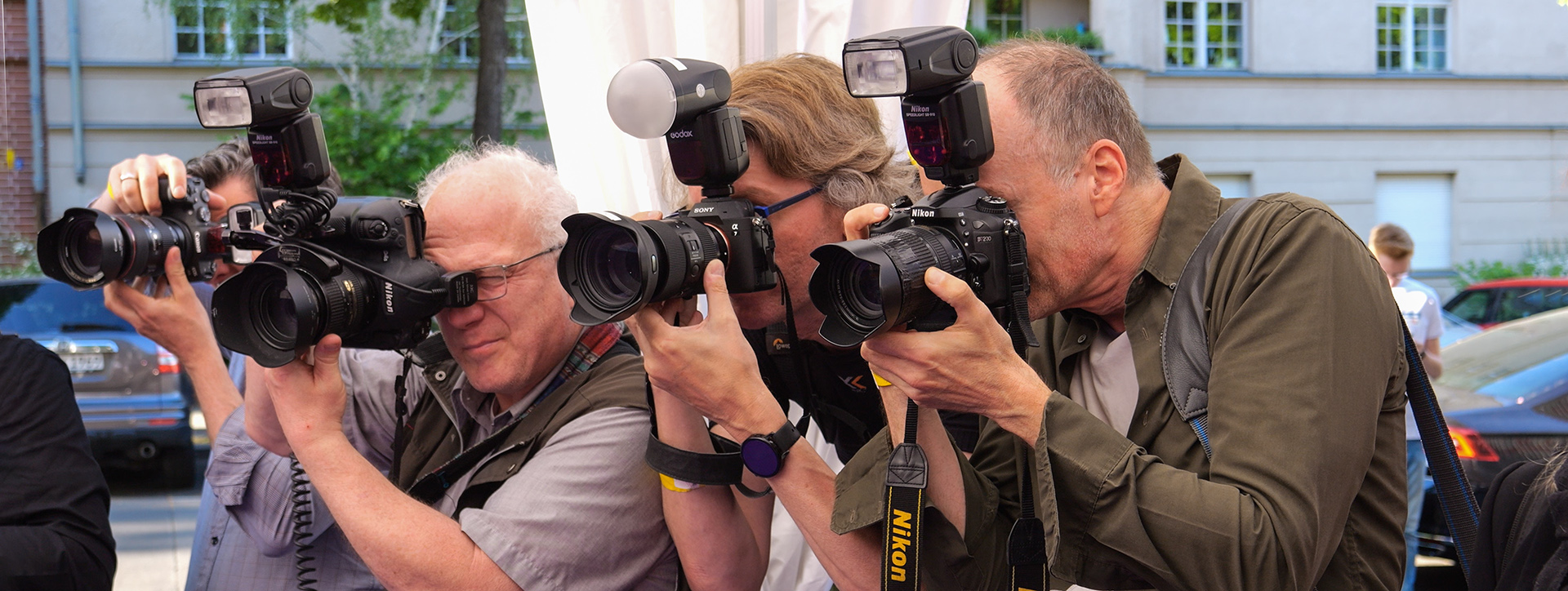 Fotografen mit Kamera auf Motivsuche bei einer Veranstaltung