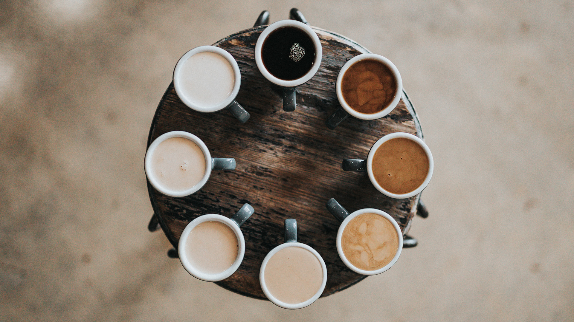 8 Kaffeetassen mit verschiedenen Kaffeespezialitäten im Kreis angeordnet wir das Ziffernblatt einer Uhr
