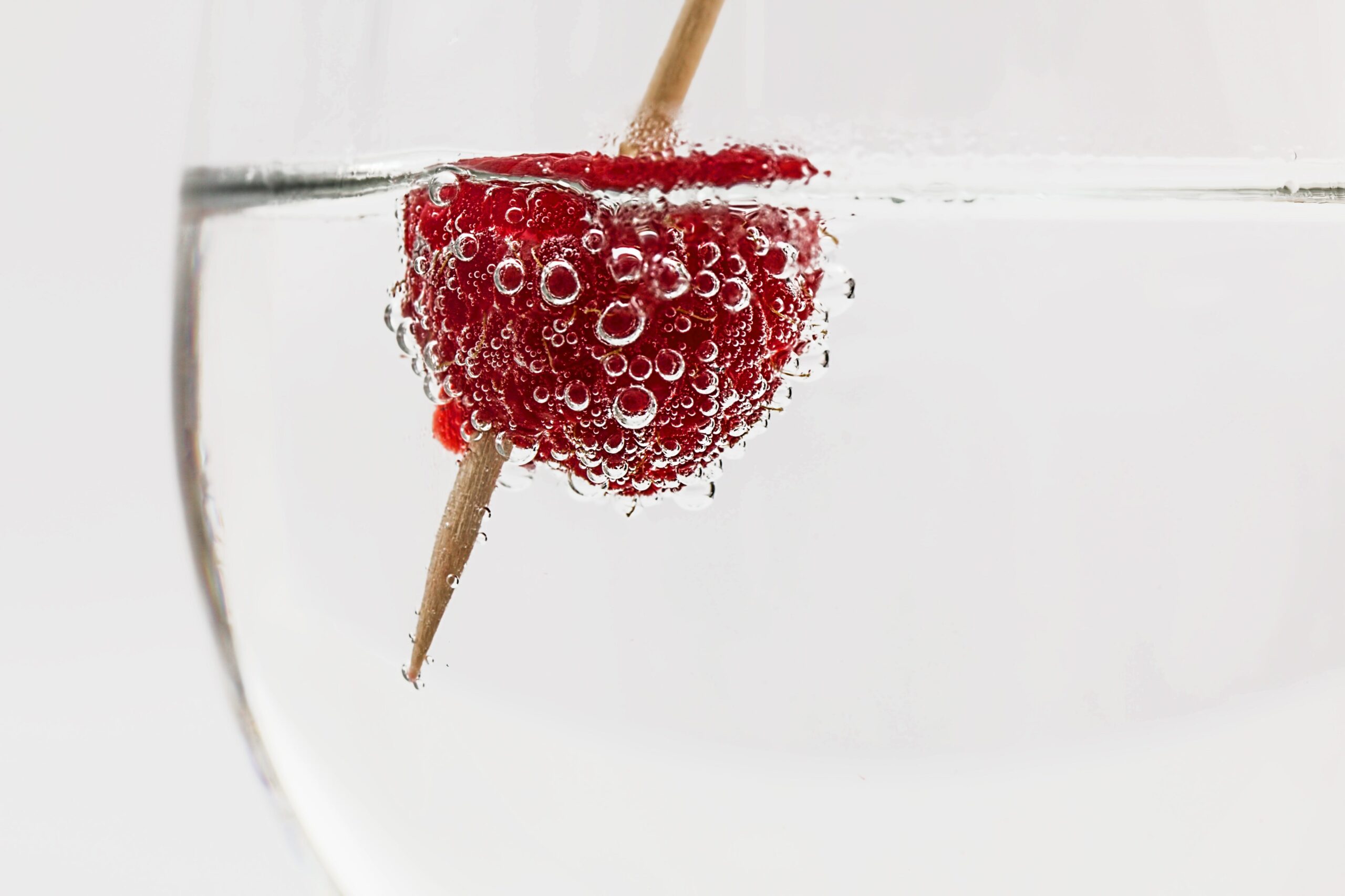 Frucht schwimmt an der Oberflächen in spritzigem Mineralwasserglas